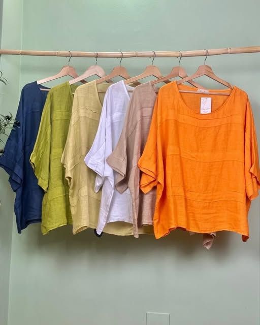 Linen tops in navy, chartreuse, white, sand and orange on wooden hangers