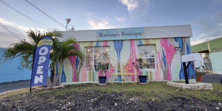 Mariann's Boutique storefront in Matlacha, hand-painted in watercolor pinks and blues, open flag out front